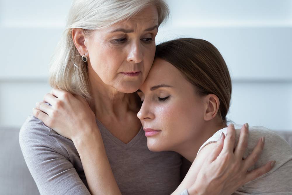 An older woman comforting a younger woman after the los of a loved one