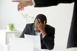 an upset black man being yelled at by a white boss