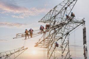 electric workers install cables tall towers