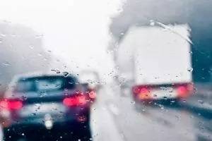 A truck and a car on a wet road