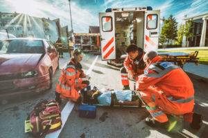 Paramedics helping an injured car accident victim