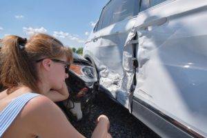 motorist observes vehicle damage after collision