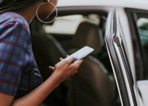 passenger checks ridesharing app before getting into car