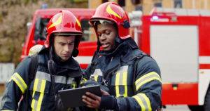 two firefighters consulting sheet
