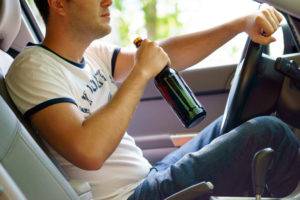 man drinking wine while driving