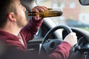 a man drinking a beer while driving