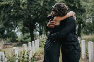 two people hug in cemetery