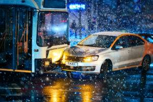 a city bus and a taxi collide in the snow