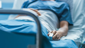 patient lays in hospital bed