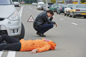 pedestrian lies on ground after getting hit by car