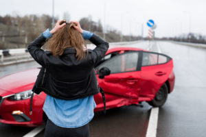 woman stares at car after fatal car accident