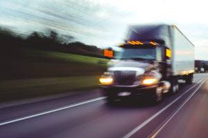 speeding-18-wheeler-on-road-headlights