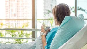 A woman recovering from a catastrophic injury drinks tea in a hospital bed. A Cape Girardeau catastrophic injury attorney can help injured victims seek justice.