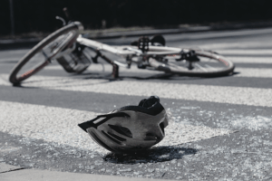 Bike helmet and bike laying down on cross walk.